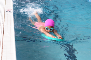 skill development swim class, child kicking in water