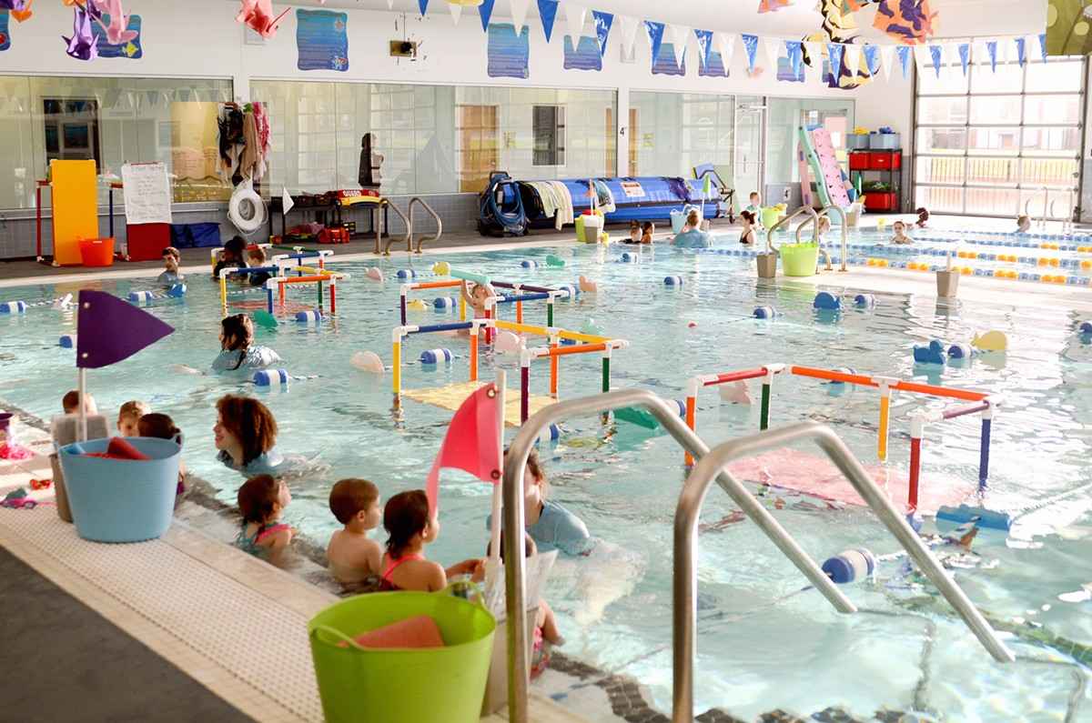 Busy indoor swim class with children practicing skills in heated pool in Charlotte & Huntersville