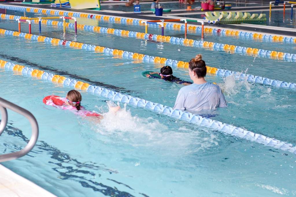 Instructor guiding children on stroke development during swim class in Charlotte & Huntersville, NC