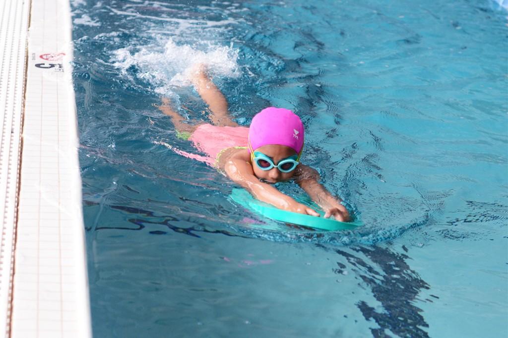 Child practicing kickboard drills in swim class, Charlotte & Huntersville, NC